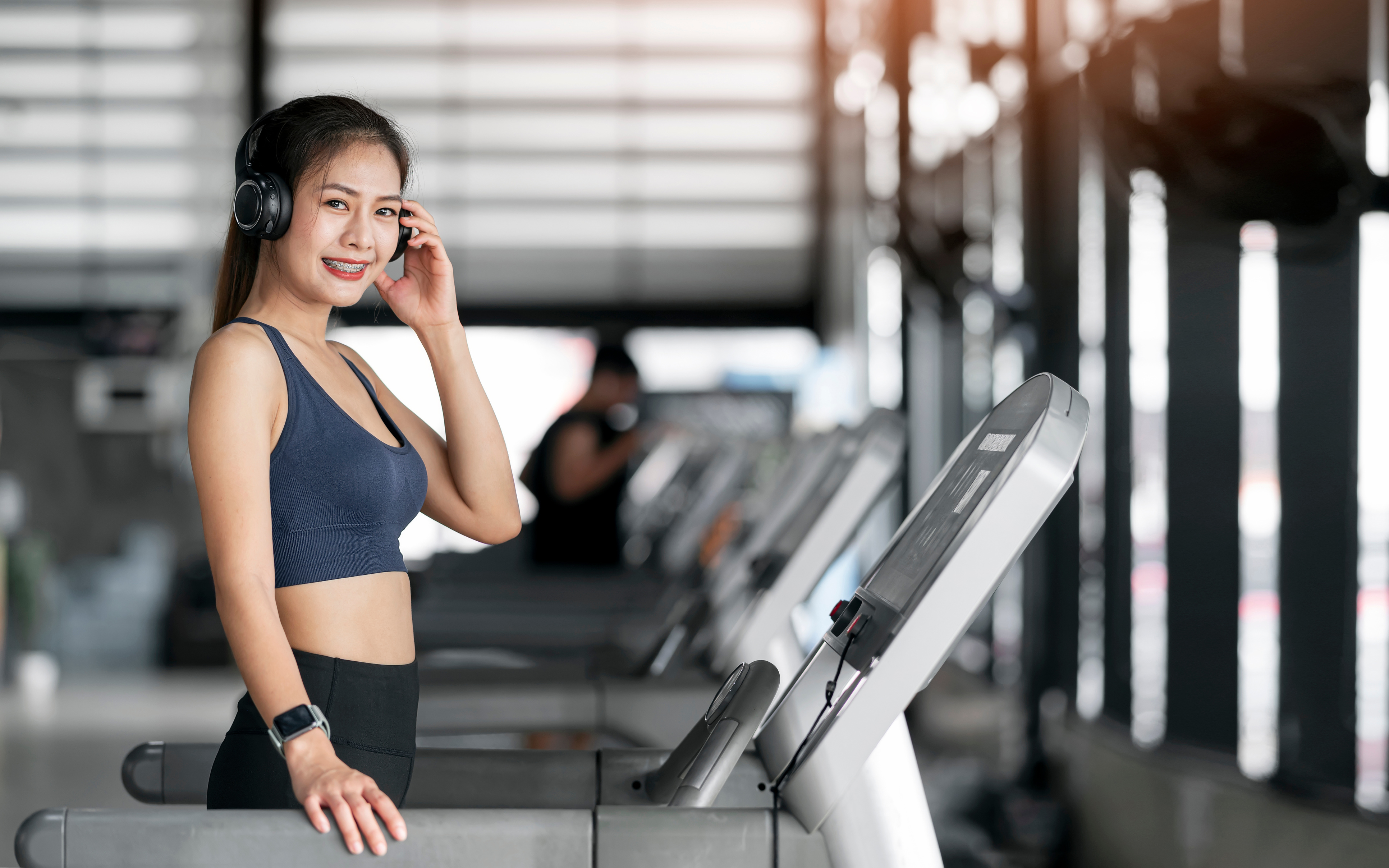 Woman with Headphone Exercising at Gym.